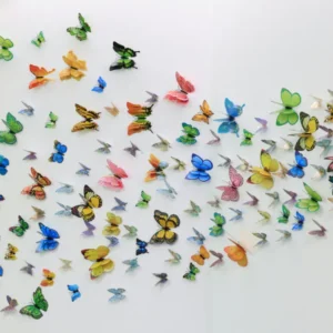 A large collection of colorful 3D decorative butterfly wall stickers in various sizes and patterns, arranged in a sweeping, wave-like motion across a clean white wall.